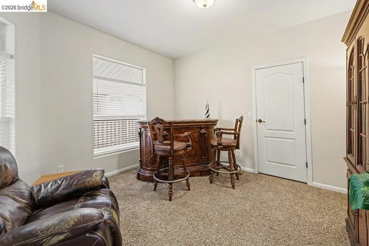 Living area featuring light carpet and baseboards