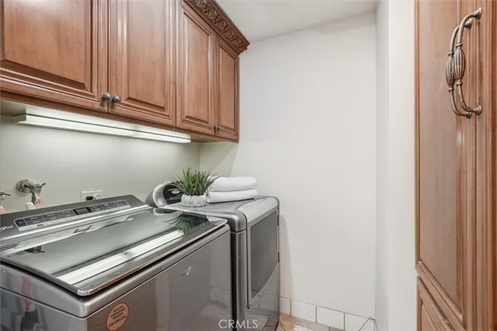 Separate laundry room with plenty of extra cabinet storage