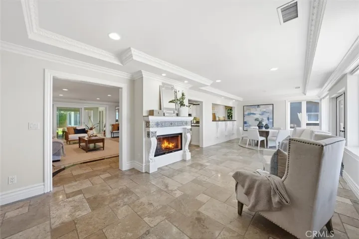 Living room with fireplace and dining room open to kitchen and french doors out to front patio