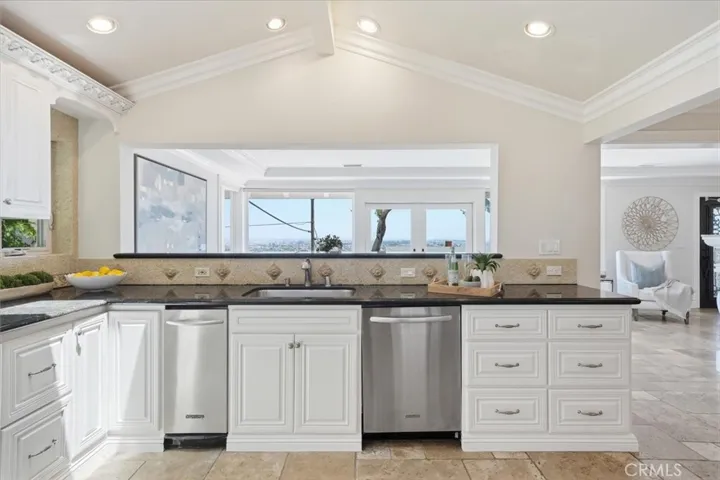 Open kitchen with maple cabinets, stainless appliances, granite counters, rain-censored, remote controlled skylights.