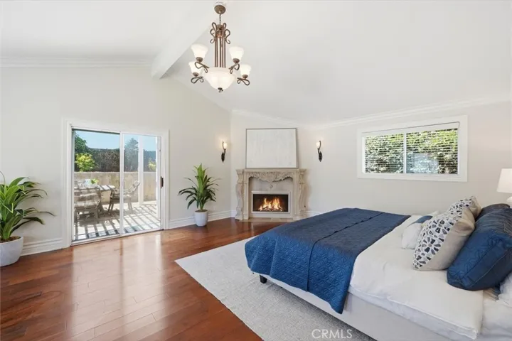 Primary suite with vaulted ceilings, sitting area, fireplace and slider to backyard