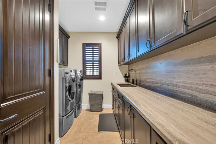 Laundry finished like the rest of the home: granite counters, full cabinetry