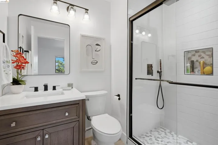Full bathroom featuring a glass-enclosed shower with pebble-tile flooring and a tiled shower niche