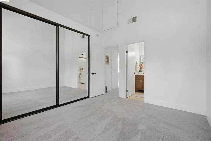 Spacious room featuring light gray carpet, white walls, and a white ceiling