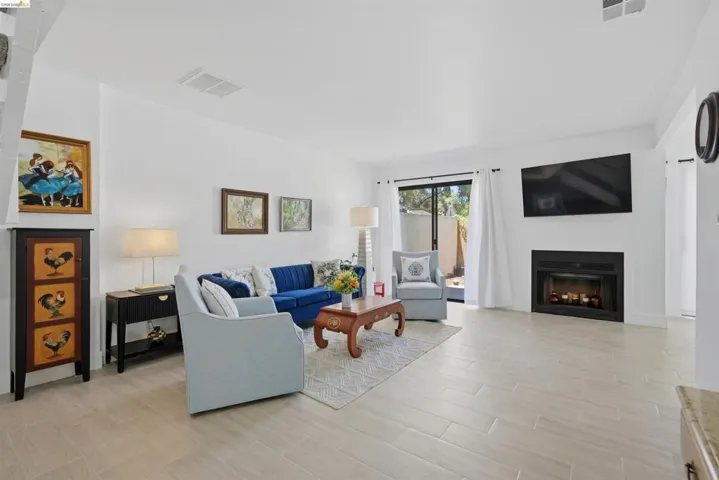 Living area featuring light wood-finish flooring, a contemporary fireplace, and sliding glass doors