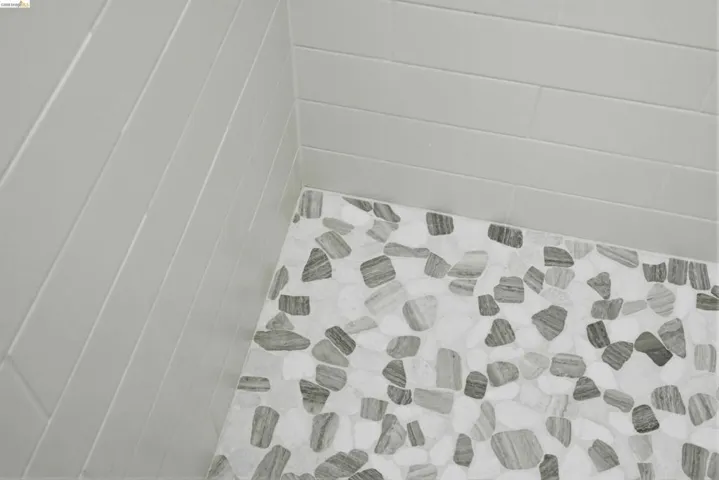 Shower with pebble-patterned floor tiling and horizontal subway wall tiles