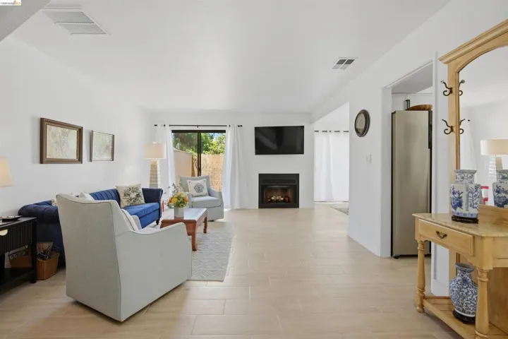 Living area featuring light-toned flooring, a modern fireplace, and sliding glass door access