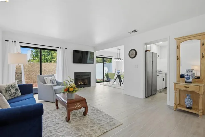 Living area featuring light-toned flooring, a fireplace with a black surround, and large sliding glass doors