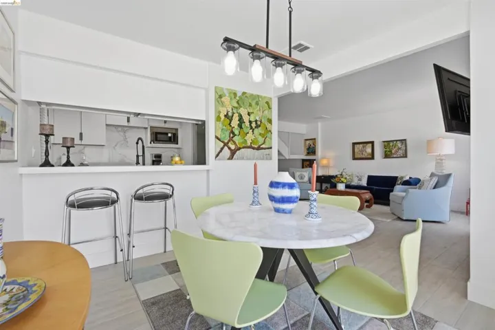 Open-concept dining area featuring a contemporary chandelier and light wood-finish flooring