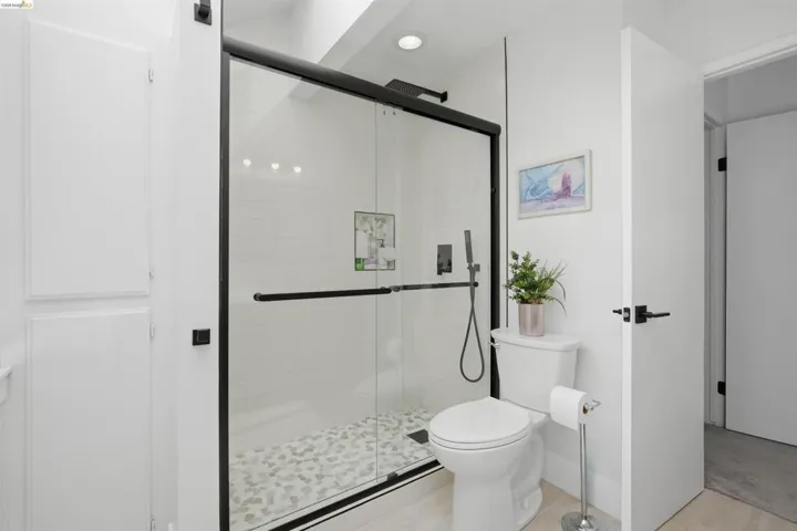 Shower enclosure with black framing, clear glass panels, and matte black fixtures