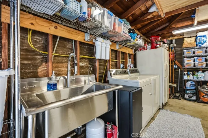 Garage with channel drain, utility sink, ceiling storage and utilities
