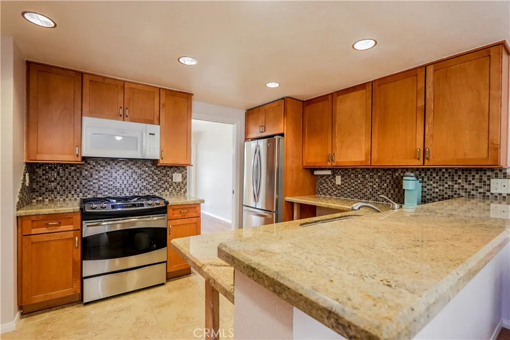Modern remodeled kitchen with stone counters, pantry, all stainless appliances including dishwasher, free standing oven and cooktop, micro, Refrigerator, hardwood cabinetry