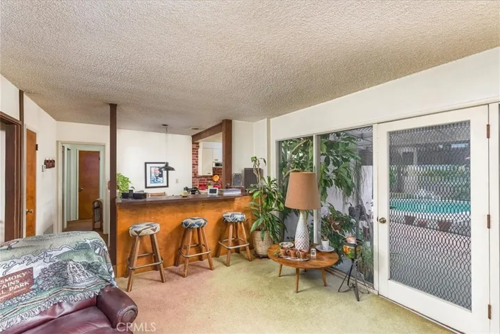 Wet bar with stools and part of the family room