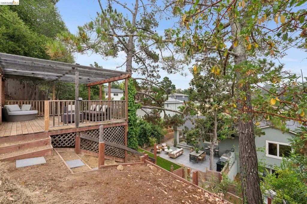 Multi-level wood deck featuring a covered pergola structure and lattice skirting