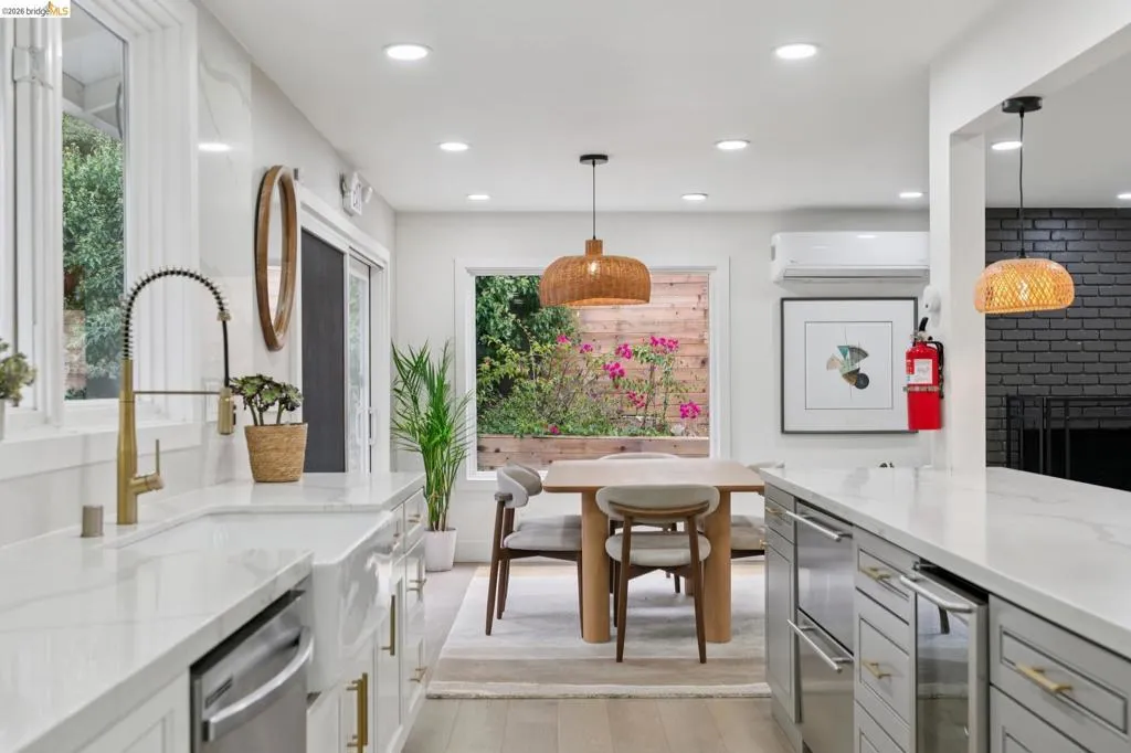 Kitchen featuring a farmhouse sink with a gold-tone faucet, white countertops, built-in dishwasher, and recessed lighting