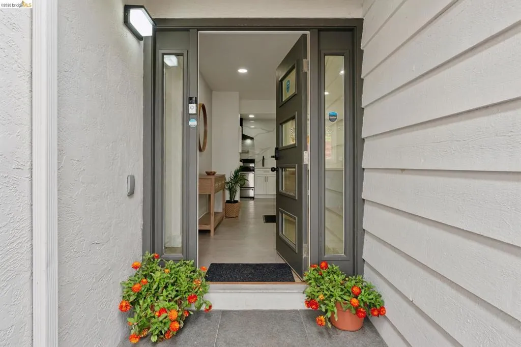 Modern entry door with multiple glass lites and a full-length sidelight, set within a textured stucco and horizontal siding exterior