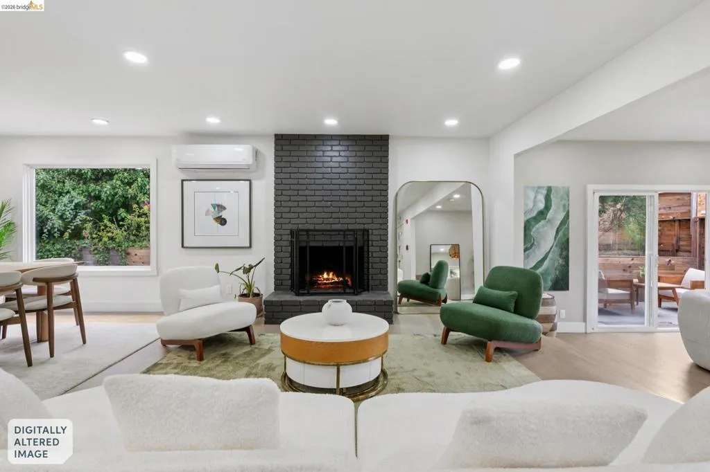 Open concept living area featuring a dark brick fireplace, recessed lighting, and light wood-finish flooring
