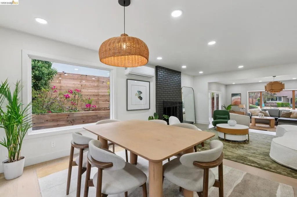 Open-concept interior featuring light wood-finish flooring, recessed lighting, and a textured pendant light fixture
