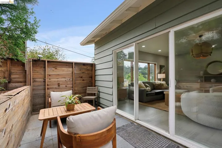 Private outdoor patio featuring wood fencing and concrete flooring