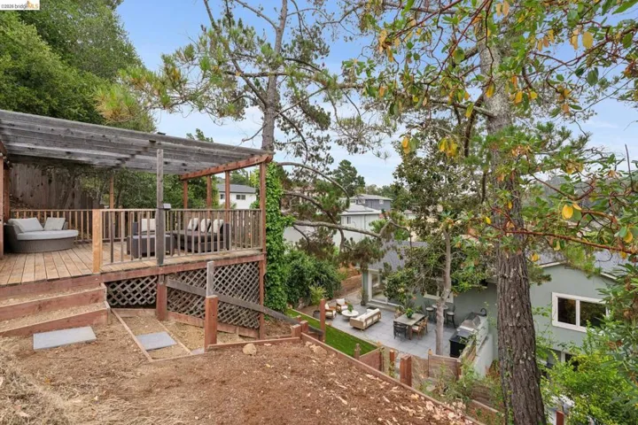 Multi-level wood deck featuring a covered pergola structure and lattice skirting