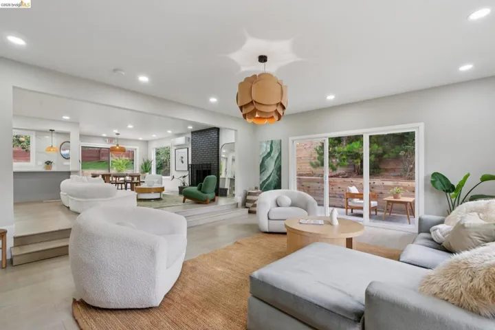 Spacious living area featuring light-toned flooring and recessed lighting