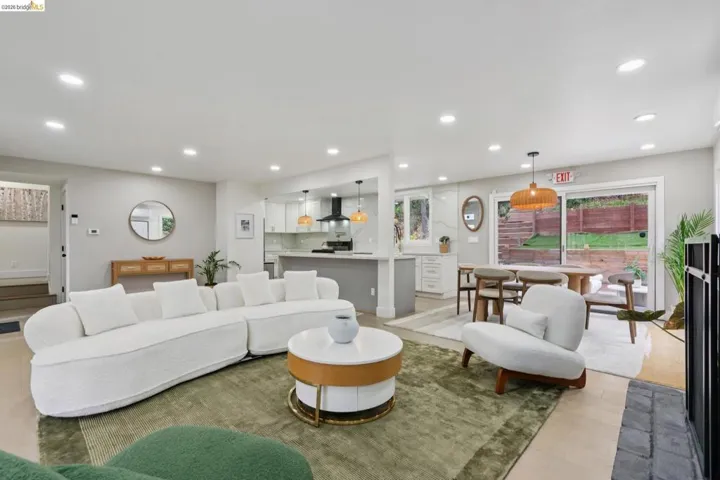 Open-concept living space featuring recessed lighting, light wood-finish flooring, and a modern kitchen with a large island and white cabinetry