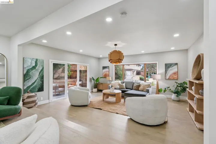 Spacious living area featuring light wood-finish flooring, recessed lighting, and a modern ceiling fixture