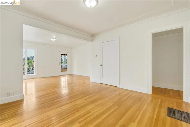 Hardwood flooring throughout expansive open room with white walls