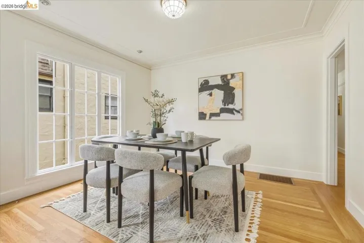 Dining area featuring wood-finish flooring, white trim, and a decorative ceiling light fixture