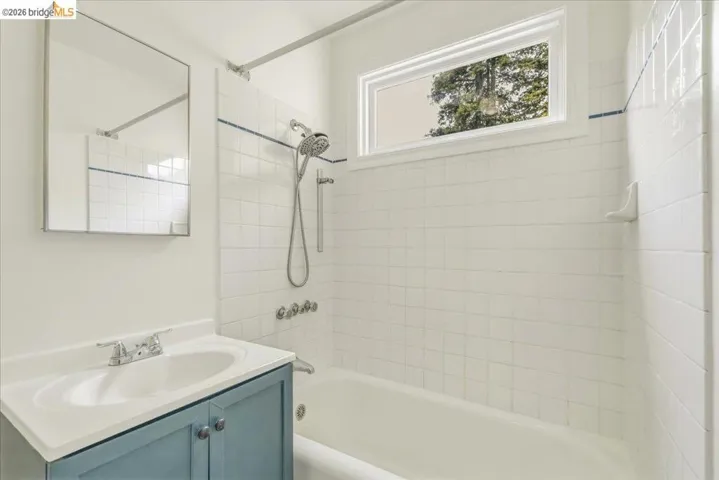 Bathroom featuring a light blue vanity with integrated sink, chrome faucet, and a large wall-mounted mirror