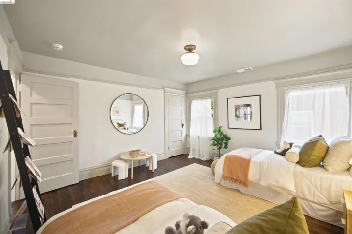 Spacious room featuring dark wood-finish flooring, multiple windows, and a ceiling-mounted light fixture