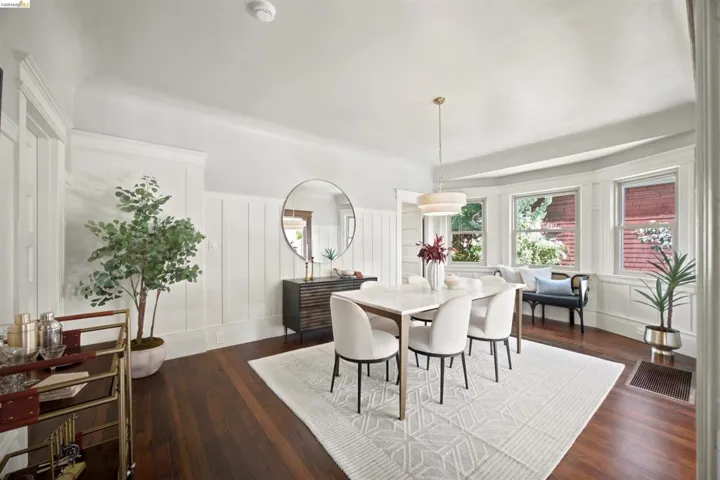 Spacious room featuring rich wood-finish flooring and extensive wainscoting