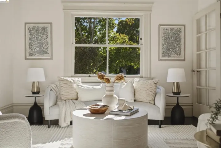 Living area featuring a large double-hung window, crown molding, and an interior French door
