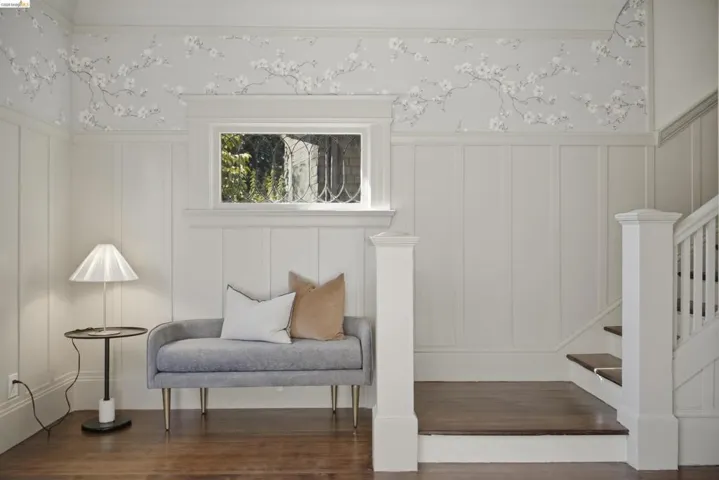 Foyer featuring hardwood flooring, white board-and-batten wainscoting, and a window with natural light