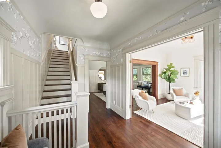 Hardwood flooring extends throughout this interior, complemented by wainscoting and decorative wall coverings