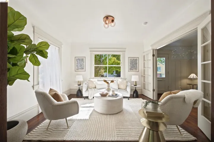 Bright living space featuring dark wood-finish flooring and white crown molding