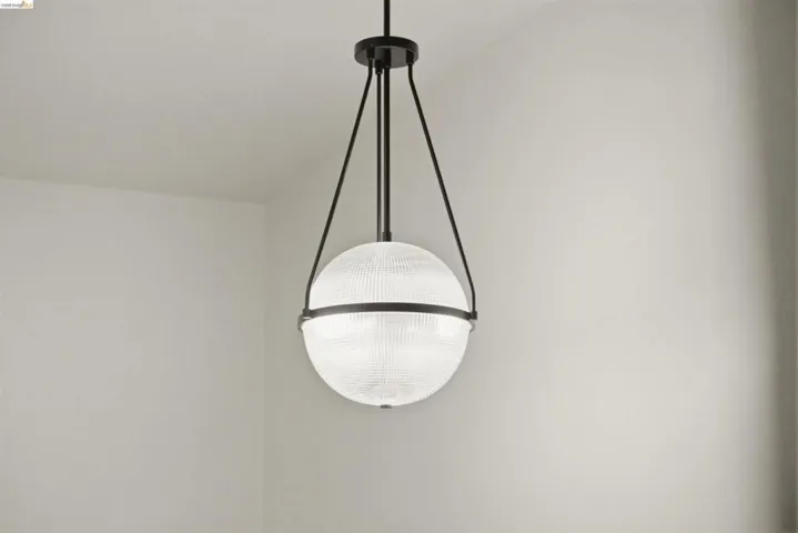 Spherical pendant light fixture featuring a ribbed glass globe and matte black metal accents