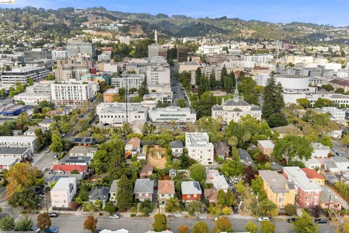 Aerial perspective showcasing a dense residential area interspersed with mature trees and urban architecture