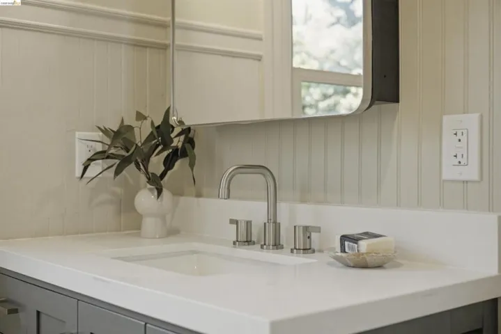 Bathroom vanity featuring an integrated sink, brushed nickel faucet, and a light-colored countertop