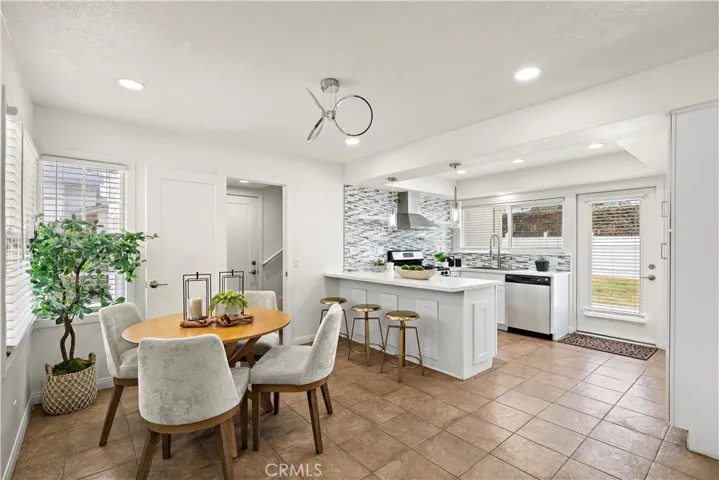 Remodeled kitchen and dining room with tile flooring, quartz countertops, breakfast bar, recessed lighting, dual pane windows