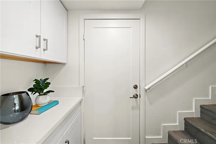Storage space off kitchen and door leading to 2 car garage, and staircase leading to upstairs 2nd primary suite