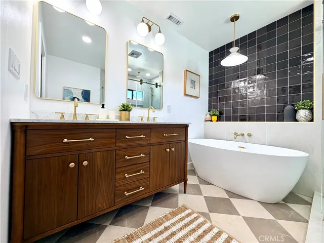 Double vanity and soaker tub, with decorator details and upscale tile choices.