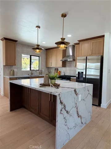 Rich, upscale quartz island and countertops flanked with neutral, gorgeous backsplash tile.