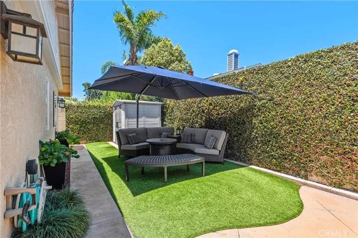 A tranquil side yard appointed with artificial turf and a place to enjoy relaxing and quiet conversations with family and friends~