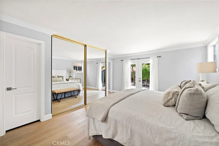 downstairs primary suite features French doors opening to the backyard