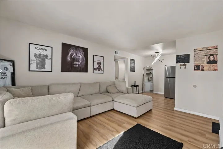 Wood-style laminate flooring flows throughout and the open layout connects seamlessly to the kitchen.