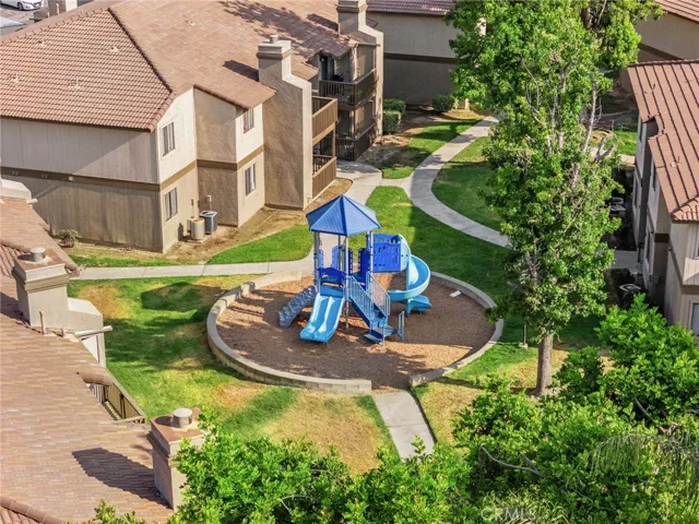 Community playground tucked among mature trees and green space — a wonderful amenity for families with children.
