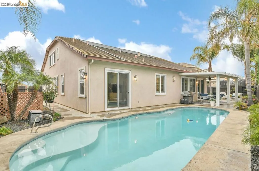 Back of house featuring stucco siding, a patio, and ceiling fan