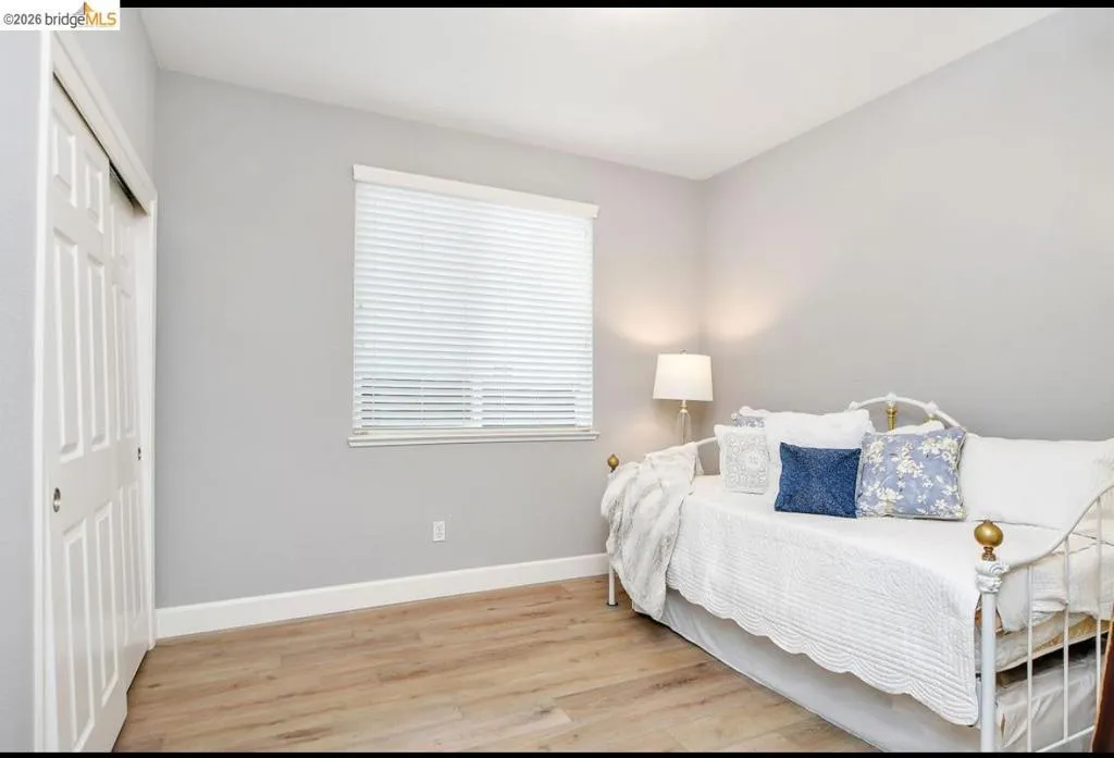 Bedroom with light wood-type flooring and a closet