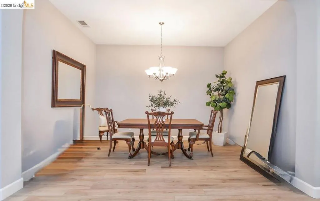 Dining area with light wood-style flooring and a chandelier